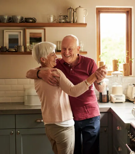 Senior couple dancing in the kitchen at home